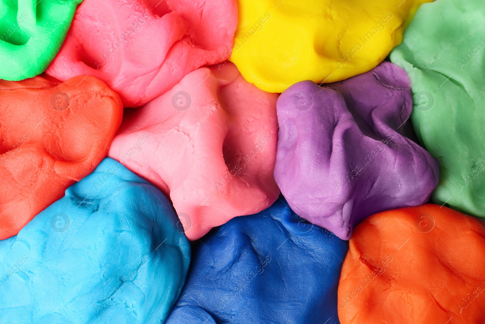 Photo of Different color play dough as background, top view