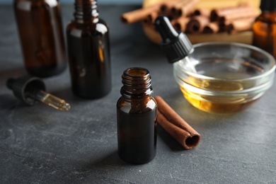 Photo of Composition with cinnamon essential oil on grey table