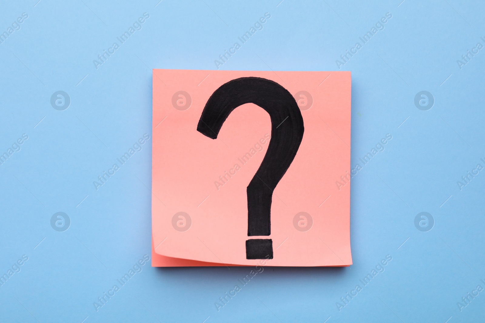 Photo of Sticky note with question mark on light blue background, top view