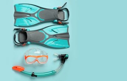Pair of flippers, snorkel and diving mask on color background, flat lay