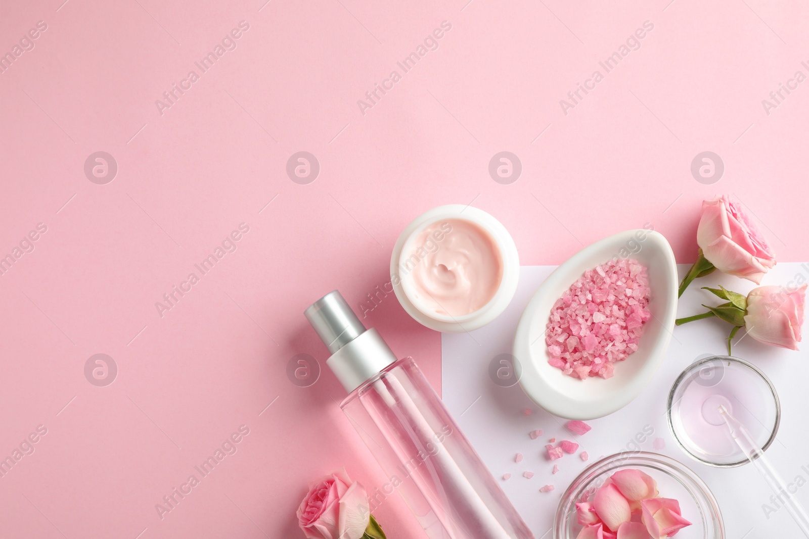Photo of Flat lay composition with rose essential oil on color background, space for text