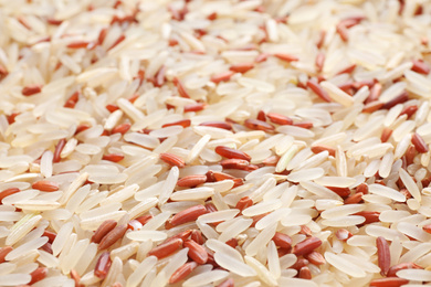 Photo of Mix of brown and polished rice as background, closeup