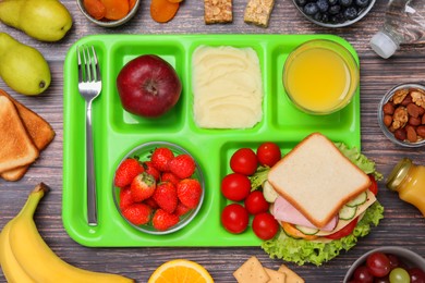 Photo of Serving tray of healthy food on wooden table, flat lay. School lunch