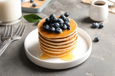 Plate with pancakes and berries on table