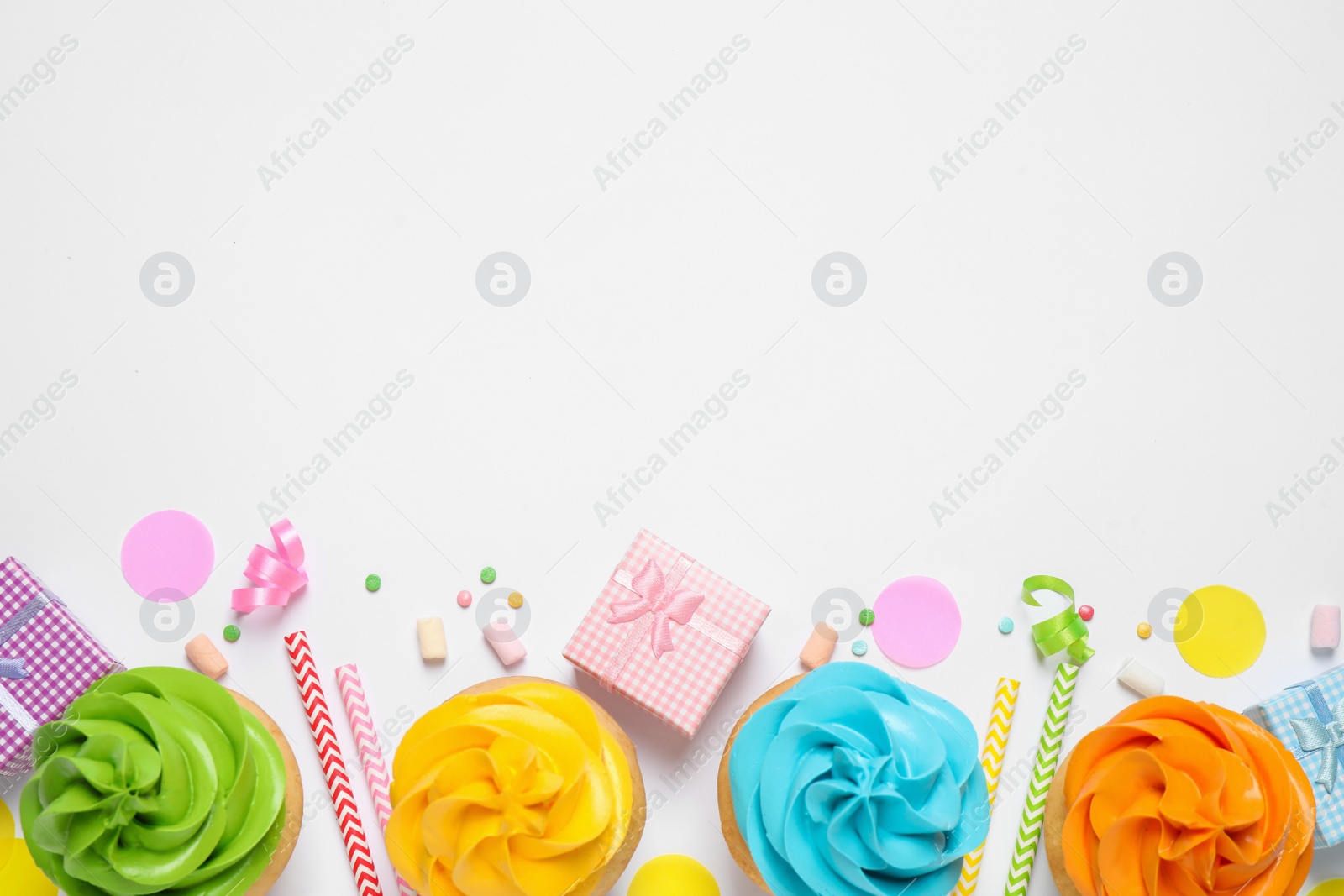 Photo of Flat lay composition with colorful birthday cupcakes on white background. Space for text