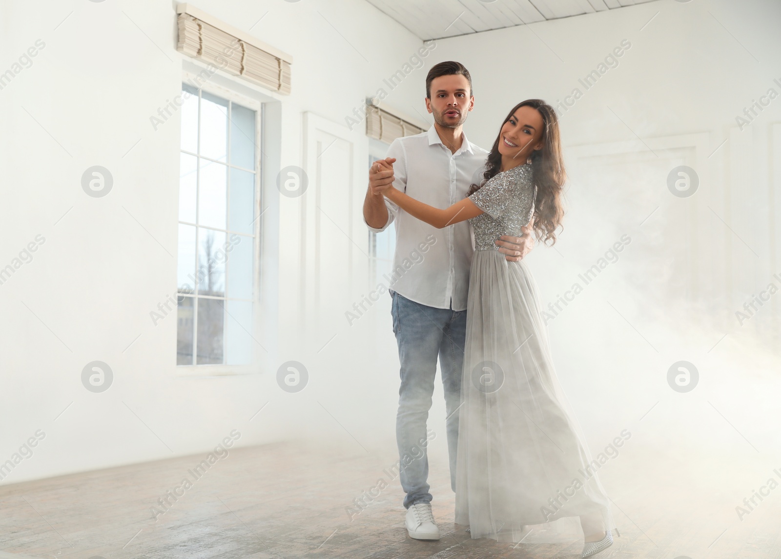 Photo of Lovely young couple dancing together in ballroom. Space for text