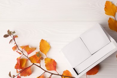 Thanksgiving day, holiday celebrated every fourth Thursday in November. Block calendar and branch with orange leaves on white wooden table, flat lay and space for text