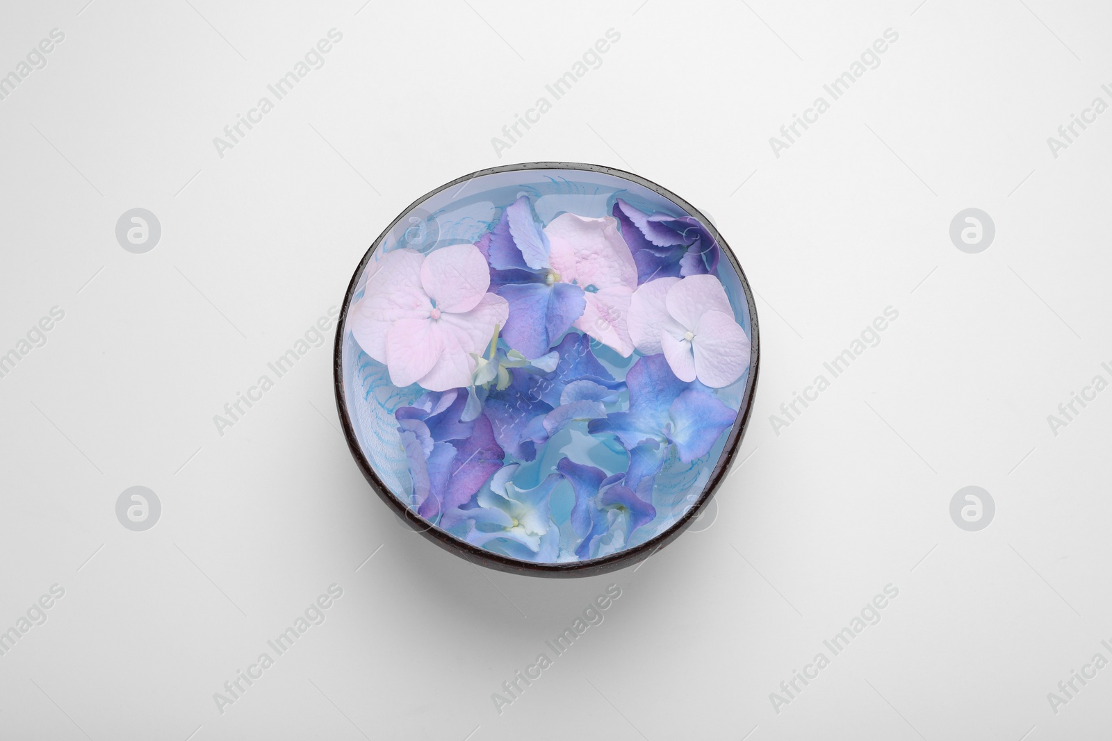 Photo of Spa composition. Aromatic water and flowers in bowl on white background, top view