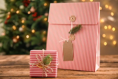 Photo of Striped Christmas gift box and bag on wooden table