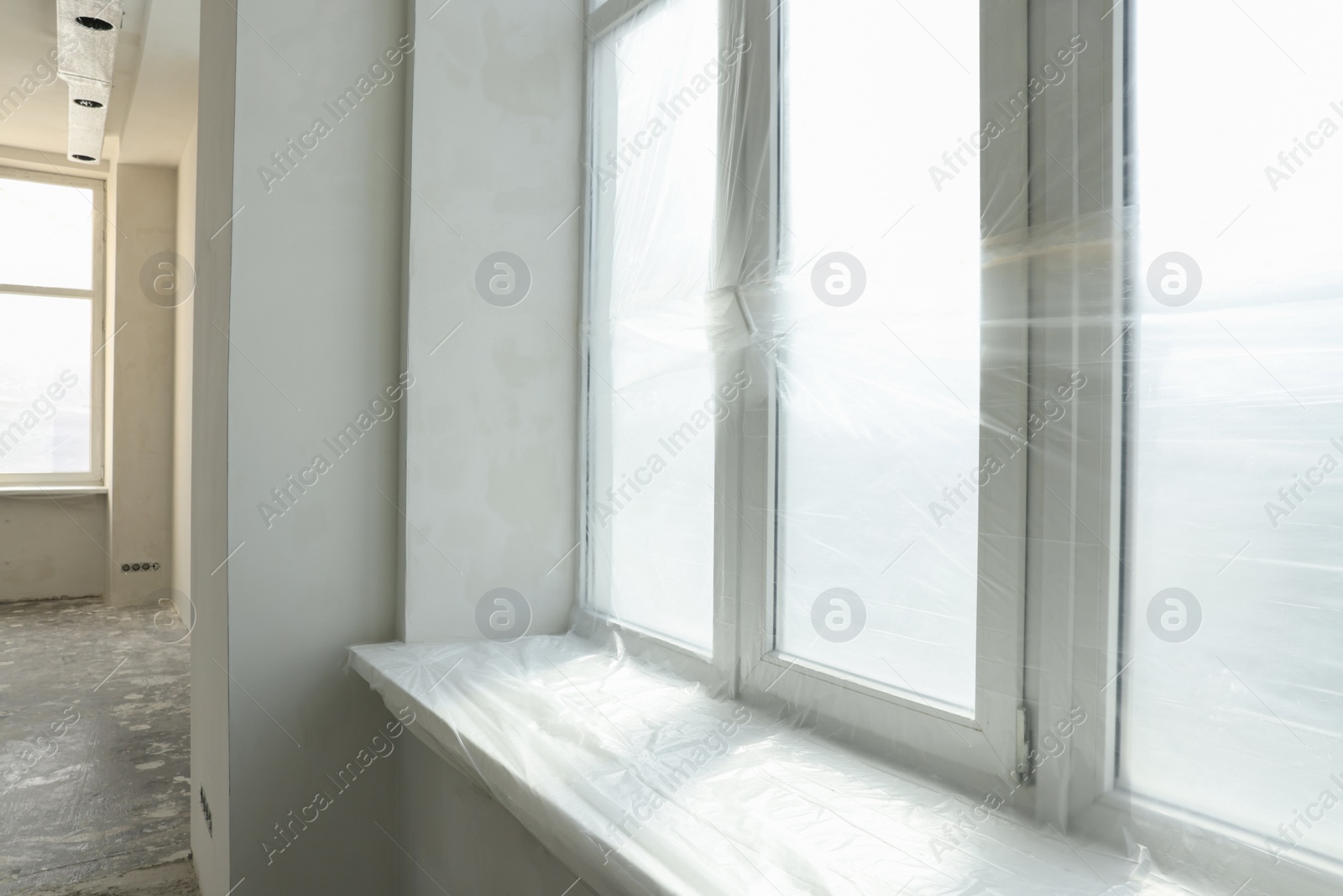 Photo of Big windows covered with plastic film in room