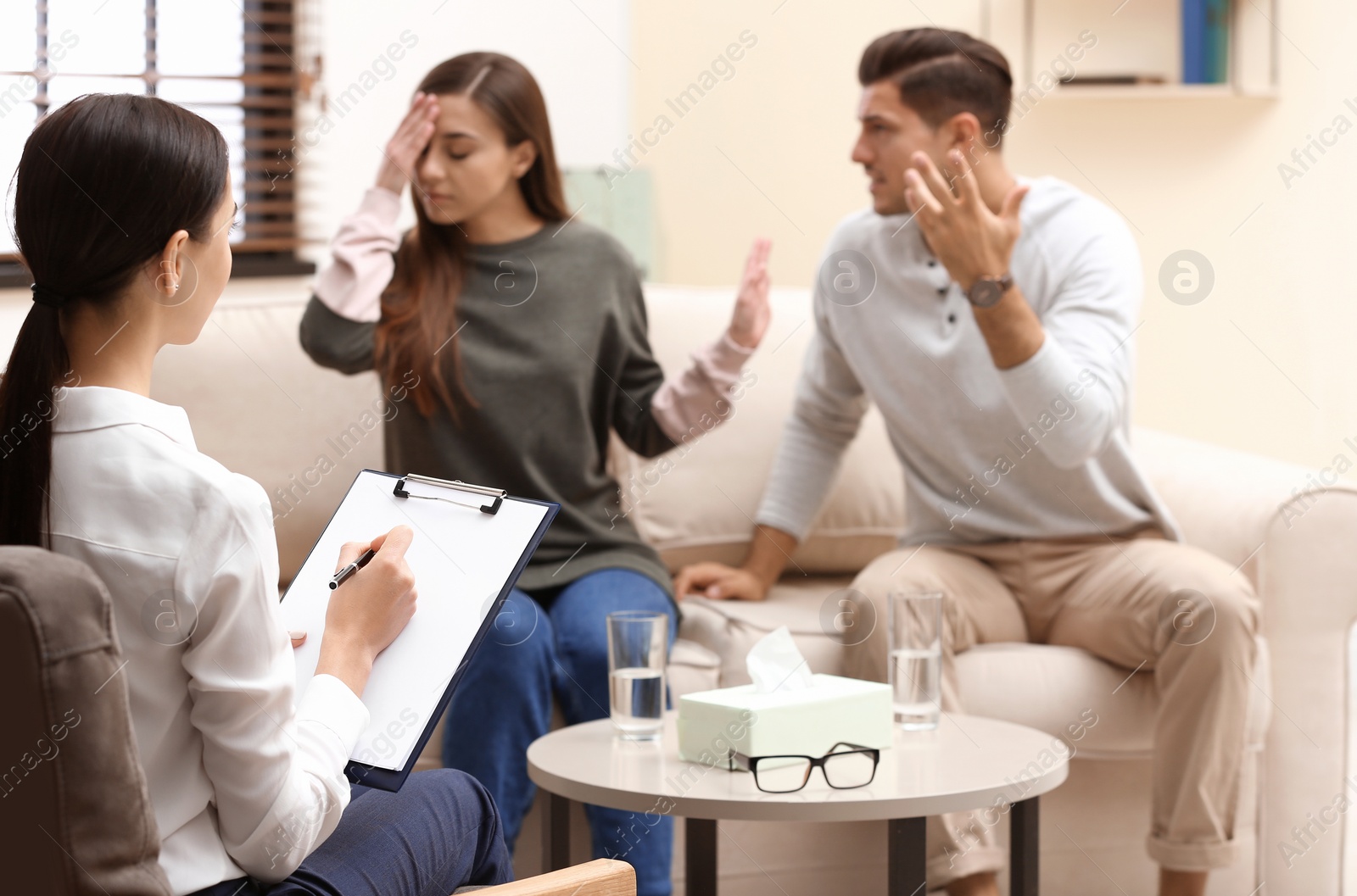 Photo of Professional psychologist working with couple in office