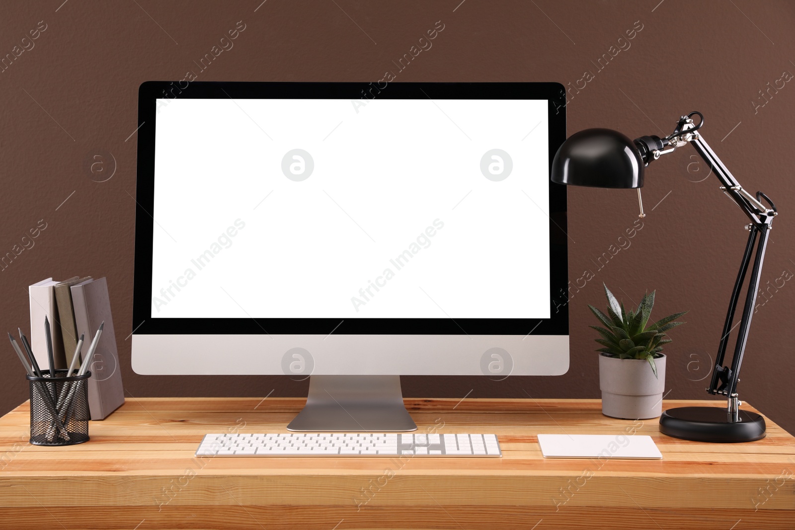 Photo of Modern computer with blank monitor screen and peripherals on wooden table indoors