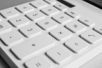 Closeup view of white calculator on light background