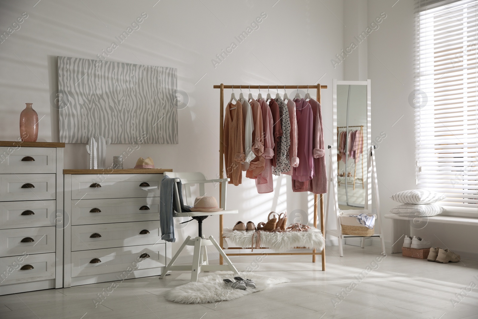 Photo of Rack with stylish women's clothes indoors. Interior design