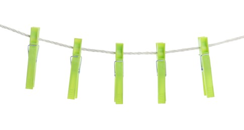 Photo of Bright green plastic clothespins hanging on rope against white background