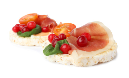 Photo of Puffed rice cakes with prosciutto, berries and tomato isolated on white