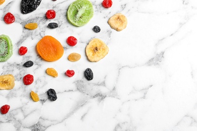 Photo of Different dried fruits on marble background, top view with space for text. Healthy lifestyle