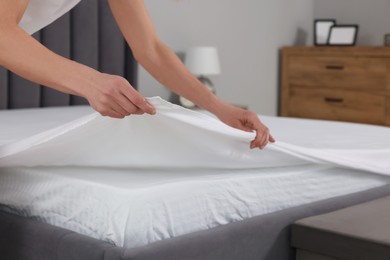 Photo of Woman changing bed linens at home, closeup