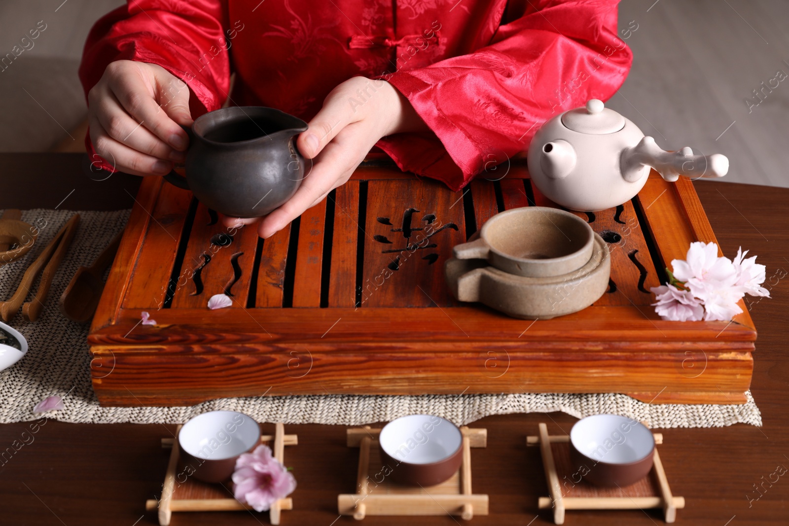 Photo of Master conducting traditional tea ceremony at table, closeup