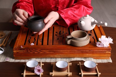 Photo of Master conducting traditional tea ceremony at table, closeup