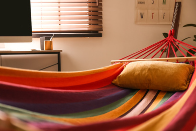 Colorful hammock with soft pillow indoors, closeup