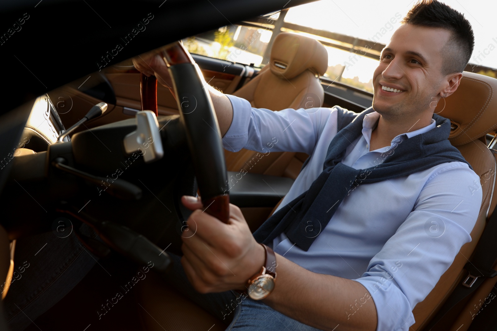 Photo of Stylish man driving luxury convertible car outdoors