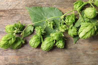 Photo of Fresh green hops on wooden background. Beer production