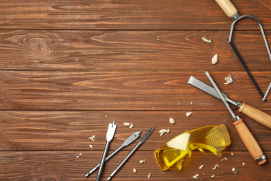 Photo of Flat lay composition with carpenter's tools on wooden background. Space for text