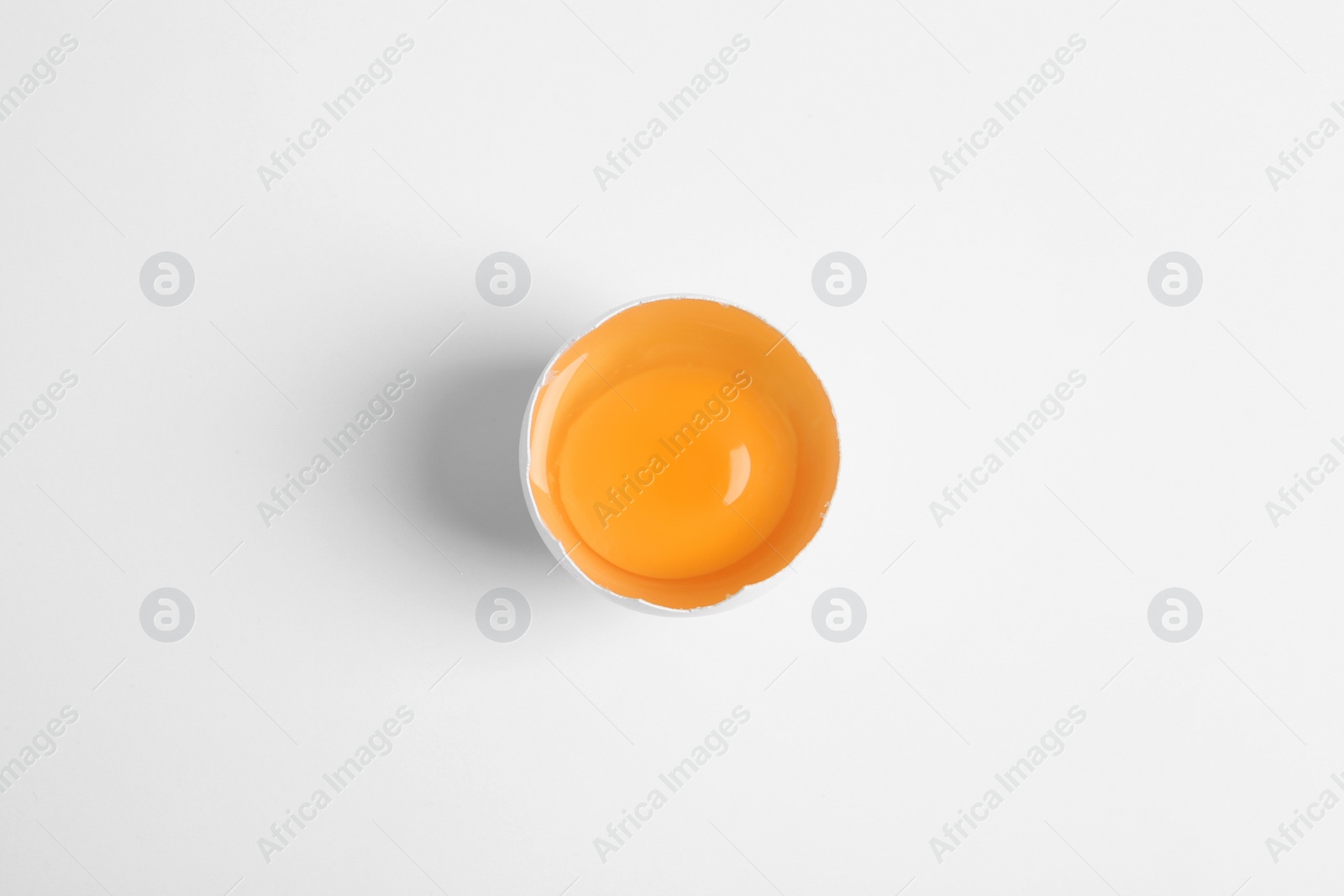 Photo of Broken raw chicken egg on white background, top view