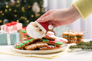 Photo of Woman with decorated Christmas cookie at table, closeup