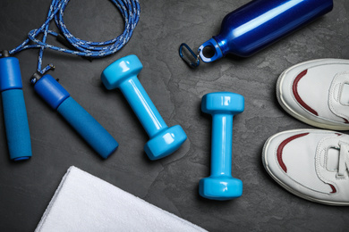Photo of Gym equipment on black background, flat lay