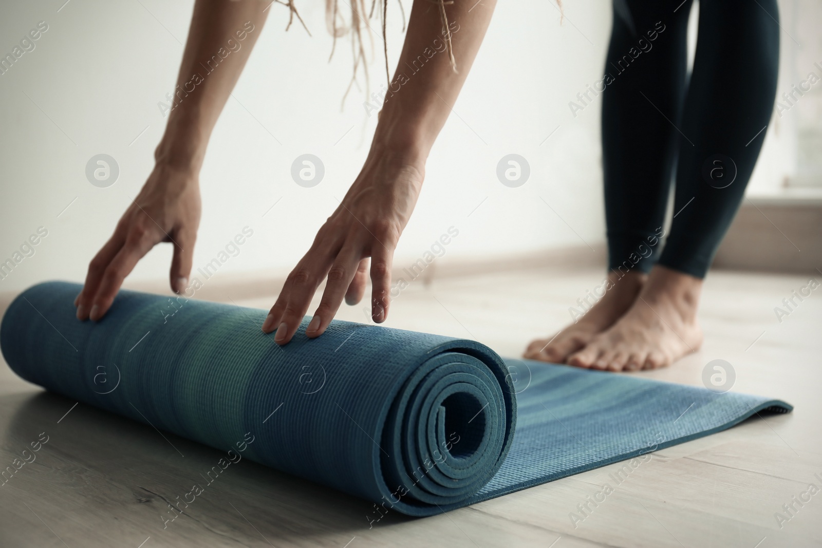 Photo of Young woman with yoga mat indoors, closeup