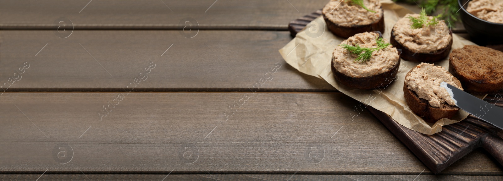 Image of Slices of bread with delicious pate served on wooden table, space for text. Banner design