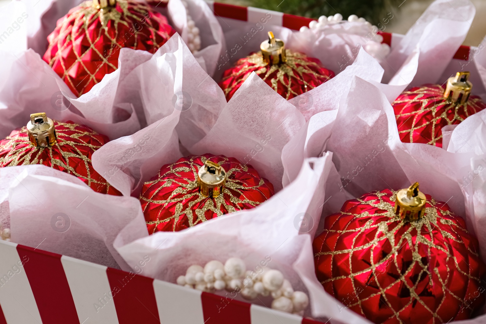 Photo of Beautiful red Christmas baubles in box, closeup