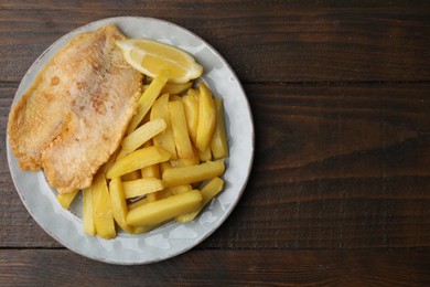 Photo of Delicious fish and chips on wooden table, top view. Space for text