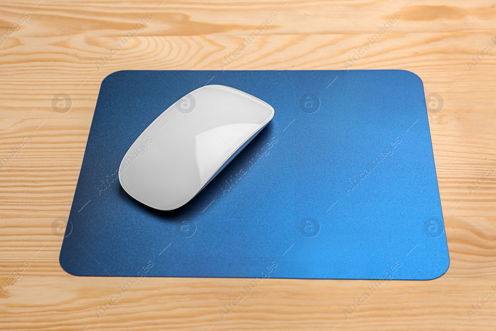 Photo of Blank pad and wireless computer mouse on wooden background