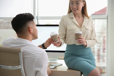 Photo of Colleagues flirting with each other during coffee break in office