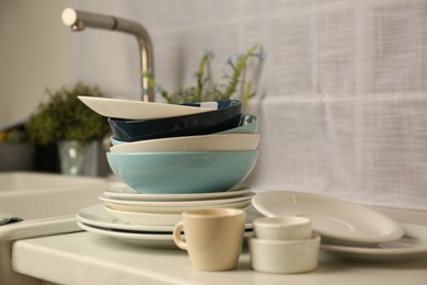 Photo of Set of clean dishware on white countertop in kitchen