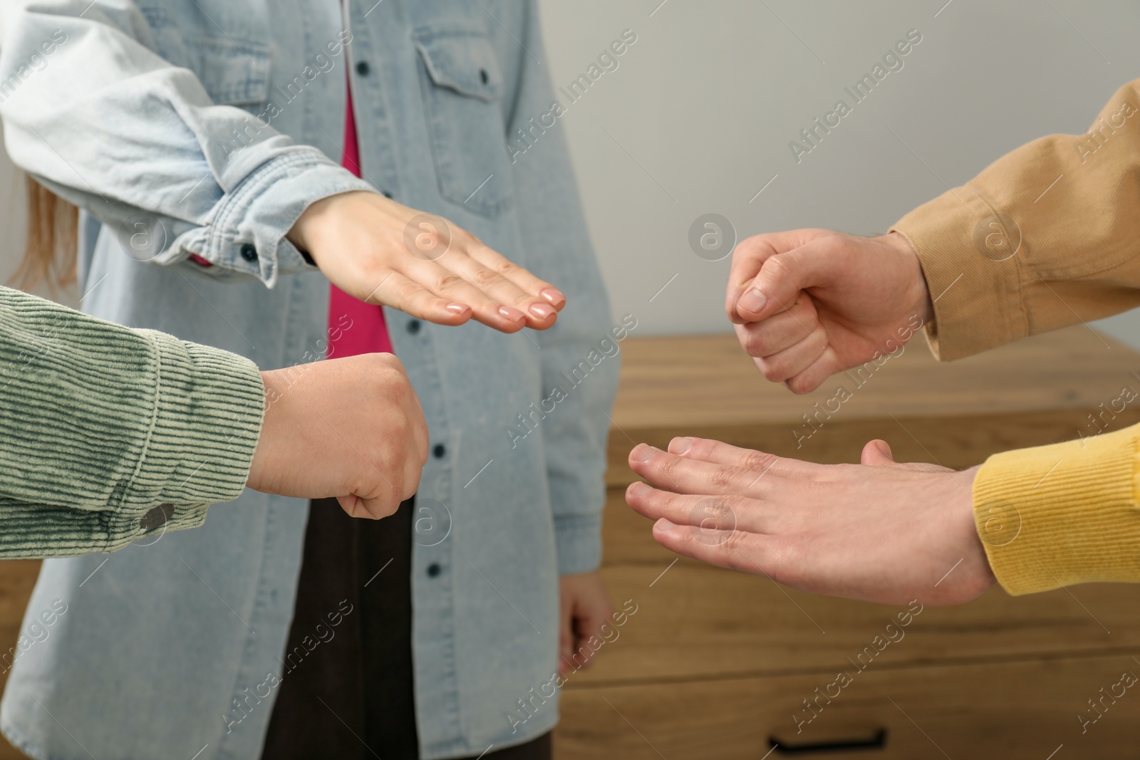 Photo of People playing rock, paper and scissors indoors, closeup