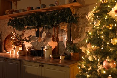 Stylish kitchen with festive decor and Christmas tree. Interior design