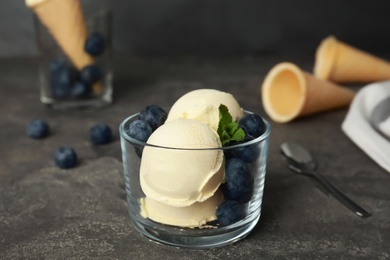 Photo of Delicious vanilla ice cream with blueberries served on table