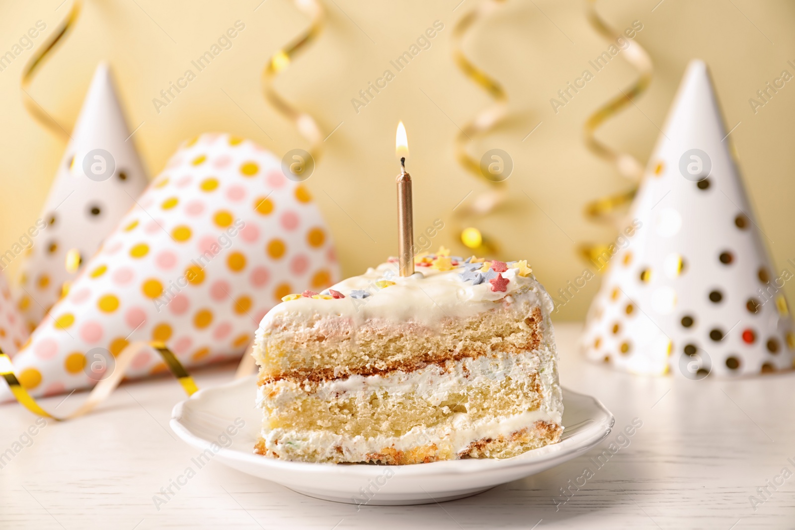 Photo of Slice of delicious birthday cake with candle on table