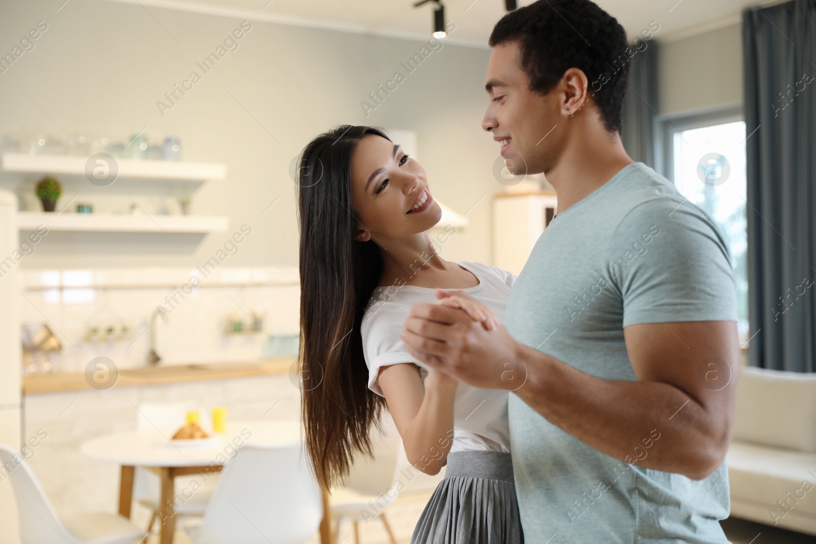 Photo of Lovely young interracial couple dancing at home