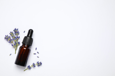 Composition with lavender flowers and natural essential oil on white background, top view