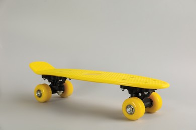 Photo of Yellow skateboard on light grey background. Sport equipment