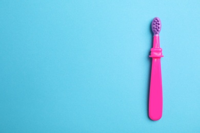 Manual toothbrush for child on color background, top view with space for text