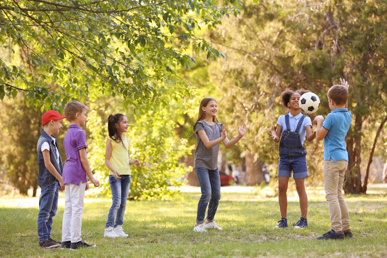 Photo of Cute little children playing with ball outdoors on sunny day