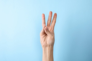 Photo of Woman showing number six on color background, closeup. Sign language