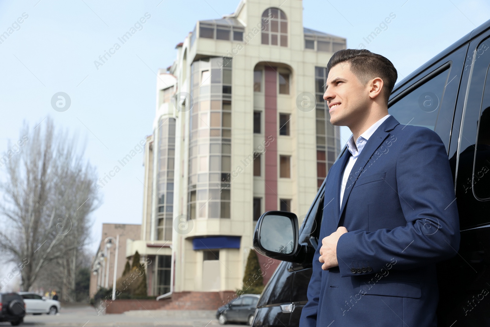 Photo of Handsome man near modern car outdoors. Space for text