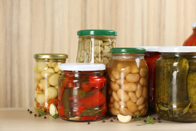 Jars of pickled vegetables on wooden table